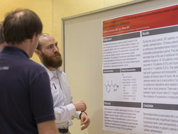 Pediatrics resident Shannon Summers, MD, (right) discusses his poster with resident William Stanford, MD, (center) and Vice Chair for Education and Residency Program Director John Frohna, MD.