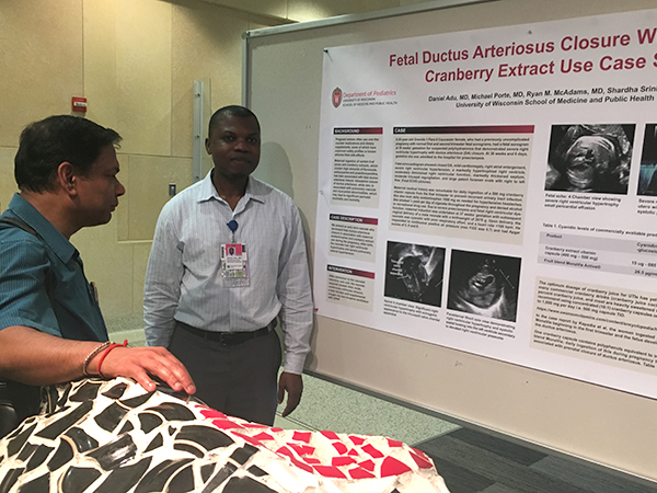 Neonatology fellow Daniel Adu, MD (on right), discusses his poster with Bikash Pattnaik, PhD