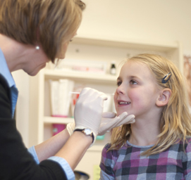 Study nurse Andrea Blom, RN, BSN, obtains an NP swab sample from five-year-old Lexi Frye at a surveillance visit.
