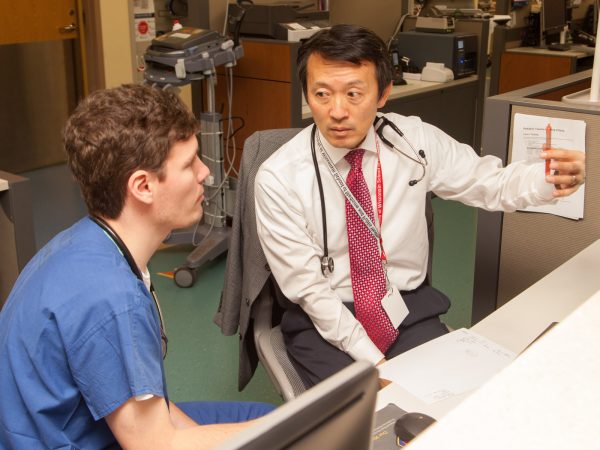 Pediatrics resident Dane Hammer, MD, talks with Michael Kim, MD, an associate professor in the Department of Pediatrics and the pediatric emergency medicine section chief in the BerbeeWalsh Department of Emergency Medicine.