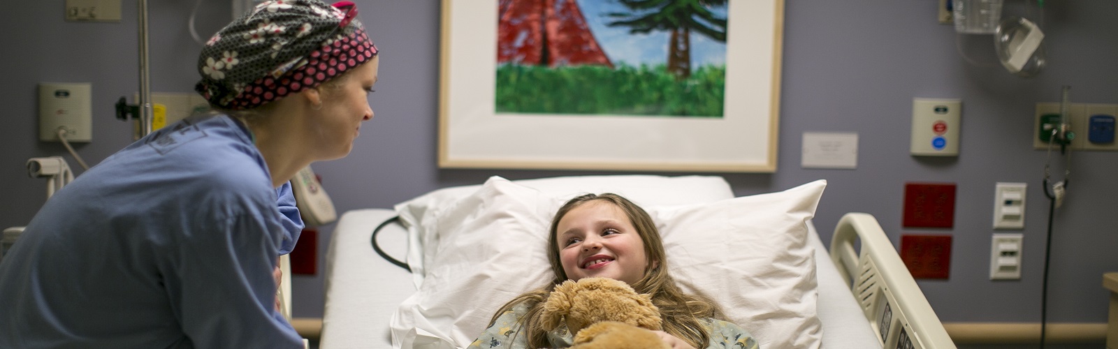 young patient in a hospital bed with a care provider