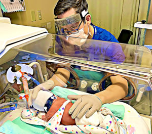 Doctor performing examination on premature baby