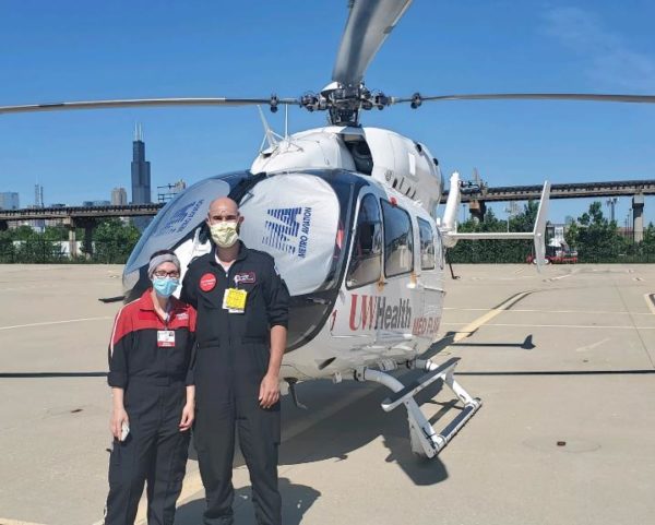 two people standing in front of helicopter