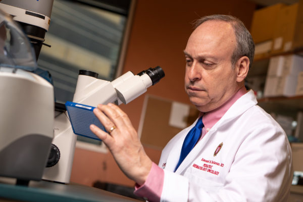 Doctor looking through a microscope