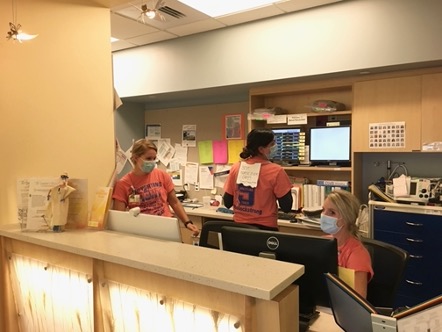 three nurses at a nursing station