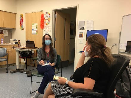 two seated doctors discussing and taking notes