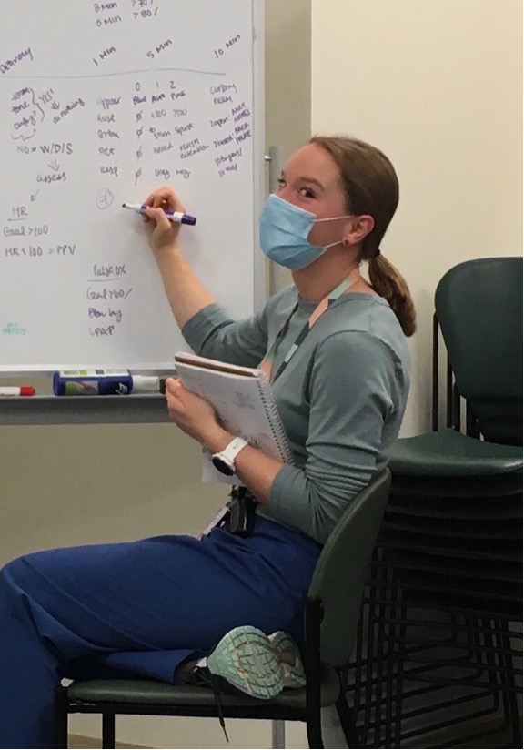 aa resident writing on a dry erase board, and she is clearly excited to be doing so