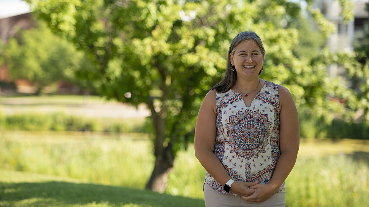 Laura Houser standing outside with a green field behind her