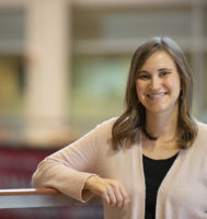 Dr. Sarah Webber standing in the HSLC atrium with her arm on a railing