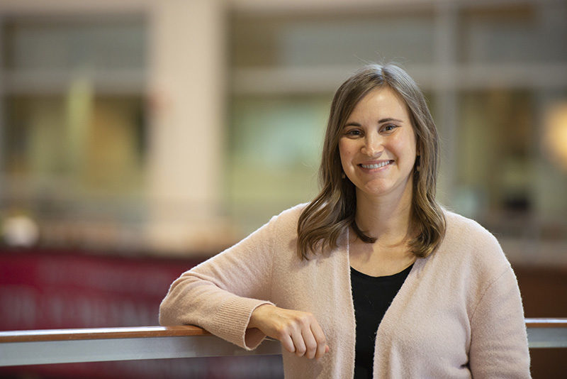 Dr. Sarah Webber standing in the HSLC atrium with her arm on a railing