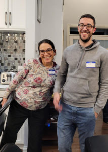 two people standing in a kitchen smiling at the camera