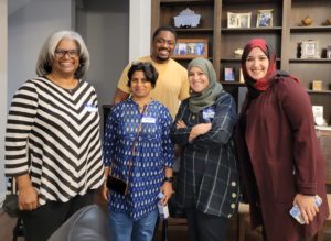 group of people standing in a dinning room smiling a camera