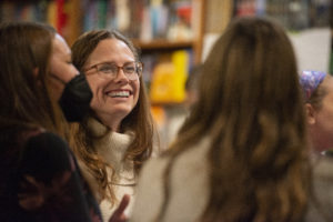 Dr. Jessica Babal smiles as she is talking to a group of Story Slam audience members.