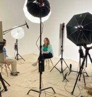 Dr. Megan Yanny is sitting in a chair across from a teen. They are both surrounded by cameras and lights.