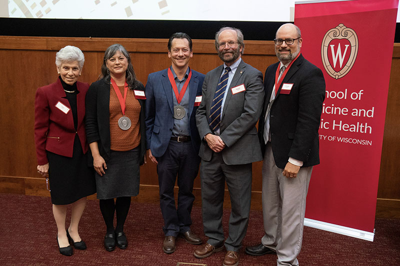 five physicians standing in a row smiling at the camera