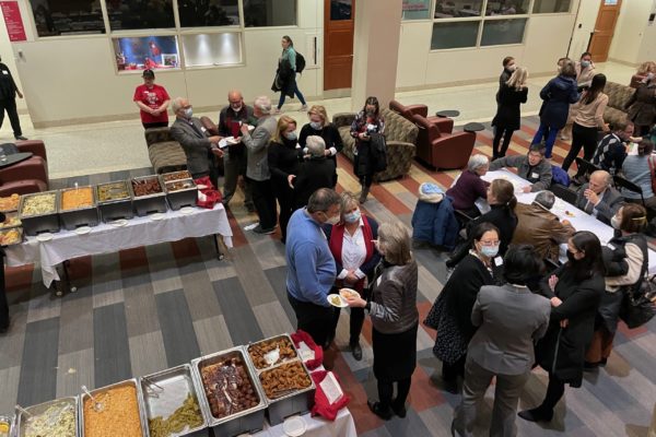 crowd at a party mingling around a buffet