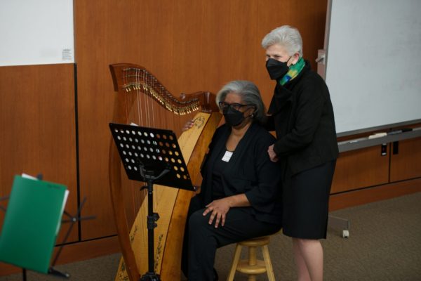 Dr. Ellen Wald with Dr. Sheryl Henderson, who is seated at a harp