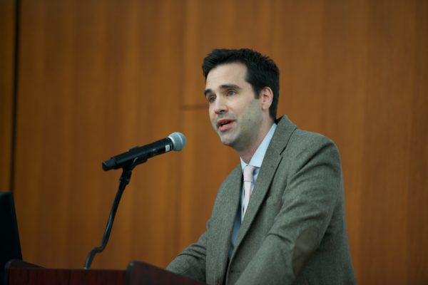 Dr. Ryan Coller speaking into a microphone