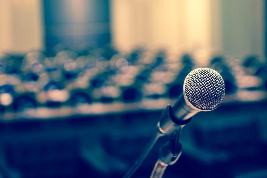 close up of a microphone with a lecture hall in the background