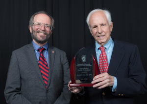 Dr. Norman Fost holding an award next to UW SMPH Dean Robert Golden