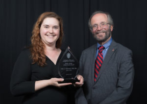 Dr. Amy Peterson holding an award next to UW SMPH Dean Robert Golden