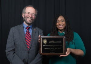 Dr. Jasmine Zapata holding an award alongside UW SMPH Dean Robert Golden