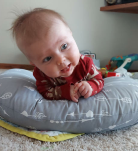 a baby laying on a pillow holding their head up