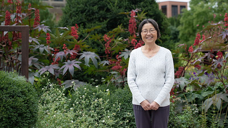 Dr. Mei Baker standing in a garden