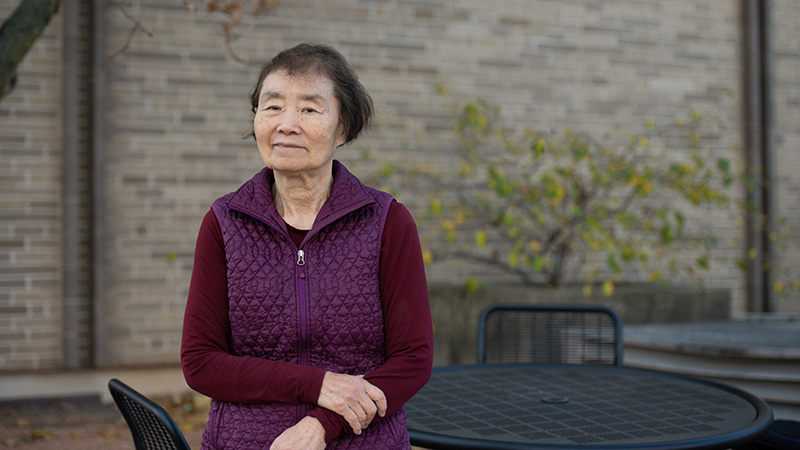 woman wearing purple shirt and vest standing outside