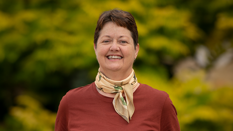 Beth Van Den Langenberg standing in front of greenery