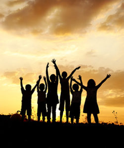 Silhouette of six children against a yellow sunset