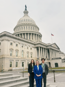 Three people standing in front of the US Capitol