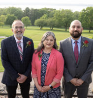 Three pediatricians standing outside with greenspace in the background