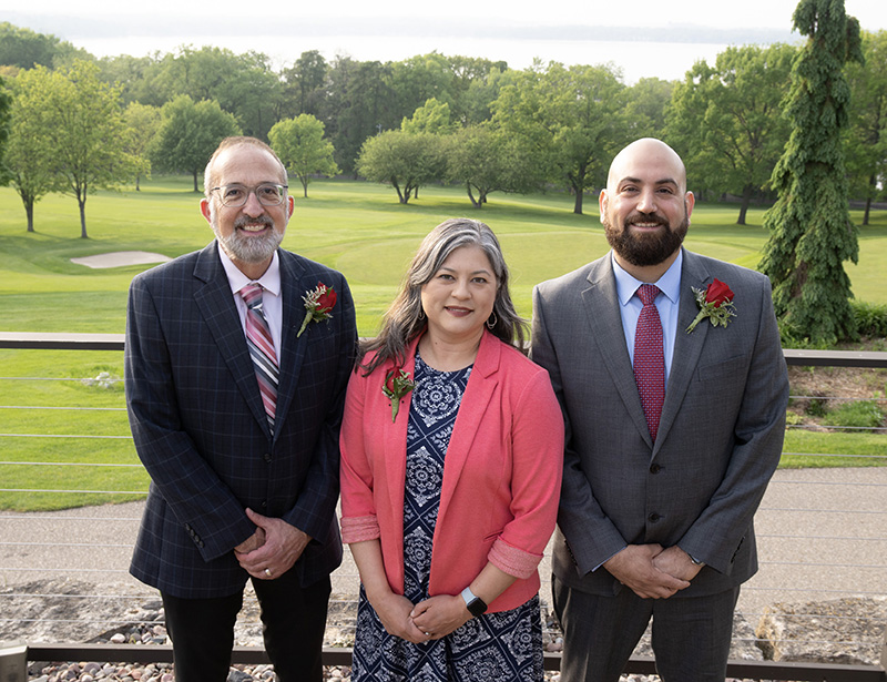 Three pediatricians standing outside with greenspace in the background