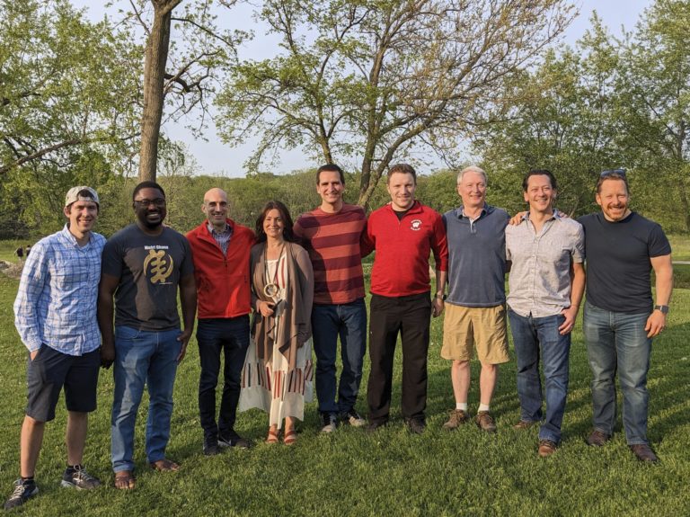 a group of fellows and doctors standing in a row outside