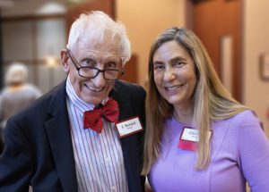 Two people dressed in professional clothing looking at camera and smiling