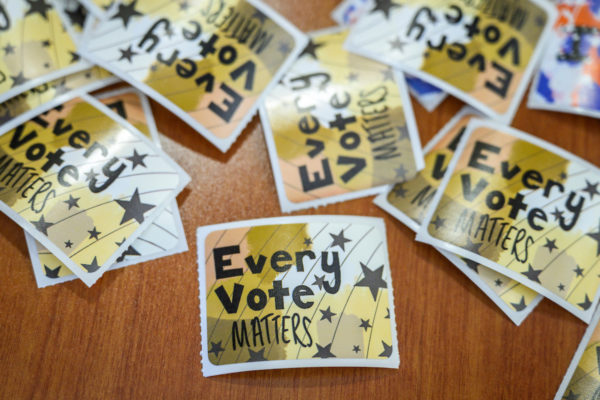 Stickers that read "Every Vote Matters" scattered on a table