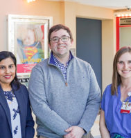 Three people standing in a children's hospital atrium