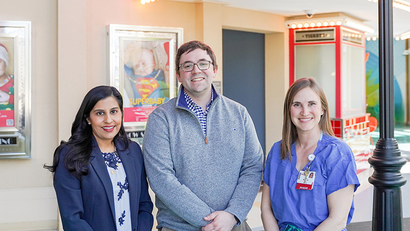 Three people standing in a children's hospital atrium