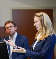 Woman standing at a podium giving a presentation.