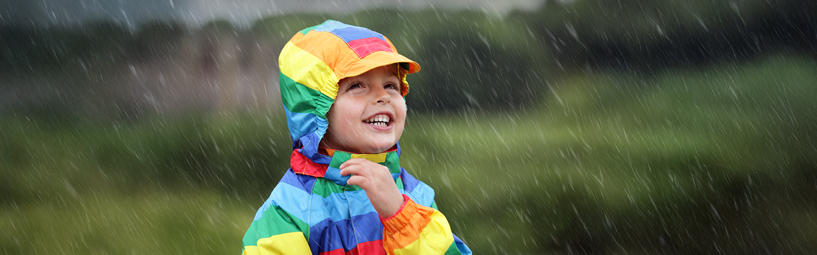 smiling child in rainbow raincoat