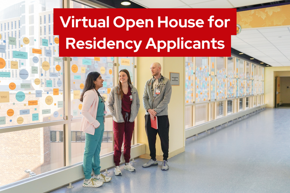 Three residents standing and talking to one another in the sky walk hallway at American Family Children's Hospital.