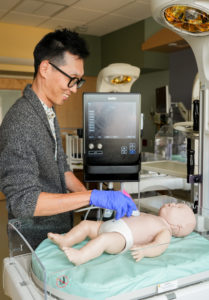 A resident practices point-of-care ultrasound on a pediatric simulation mannequin. 