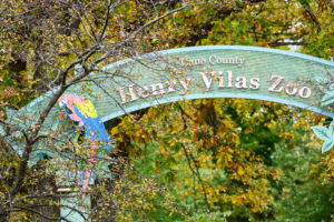 Tree foliage changing seasonal color frames an arched sign at the Henry Vilas Zoo in Madison, Wis., during autumn on Oct. 23, 2017. The zoo is community-favored destination near the University of Wisconsin-Madison campus.