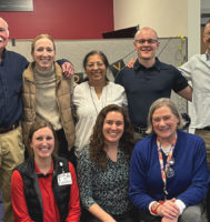 A group of people posing for the camera and smiling.