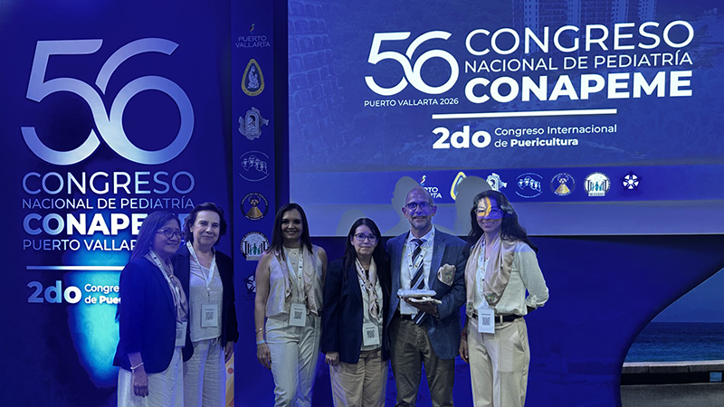 Dr. Norell Rosado with a group of colleagues standing in front of conference signage.