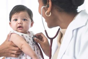 A doctor checking a baby's heart.