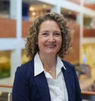 Dr. Brigid Gregg standing in a building atrium.