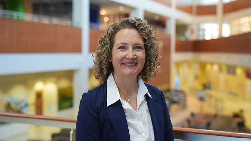 Dr. Brigid Gregg standing in a building atrium.