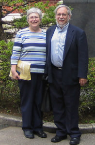 Susan Katcher and Dr. Murray Katcher standing outside with greenery in the background.